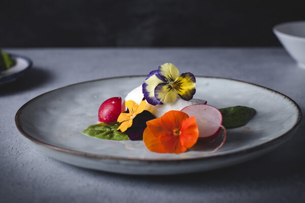 Teller mit Radieschensalat und essbaren Blüten, Bild von Charlotte Draycott